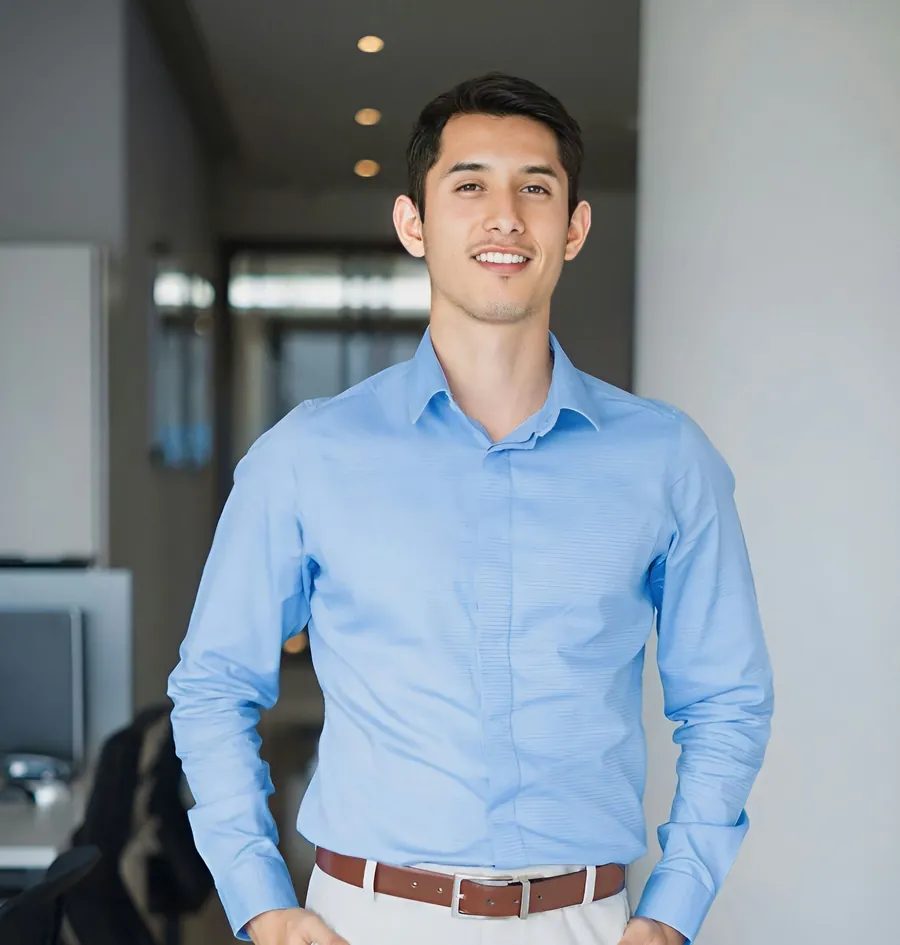 Smiling man in a blue shirt standing in an office